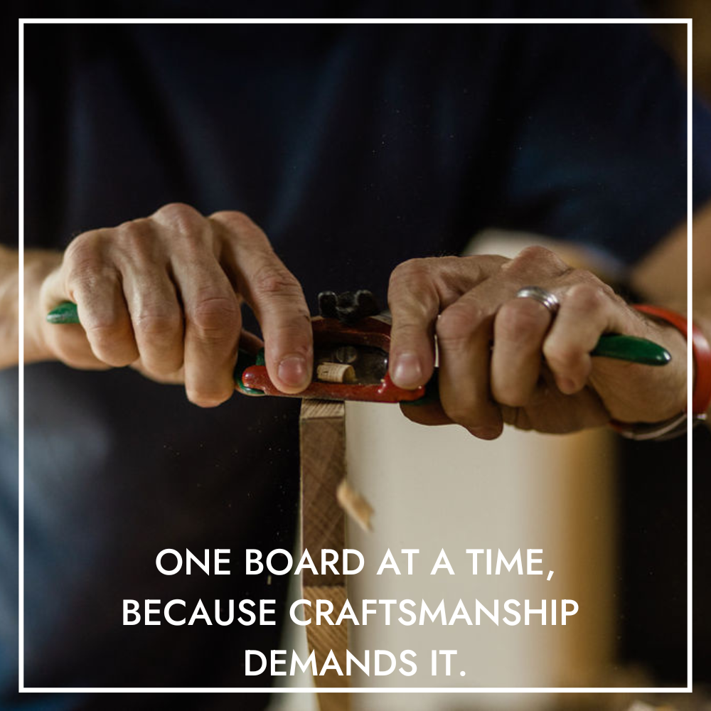 A Deviate longboard being hand shaped with a spokeshave - wood chips flying in the air.