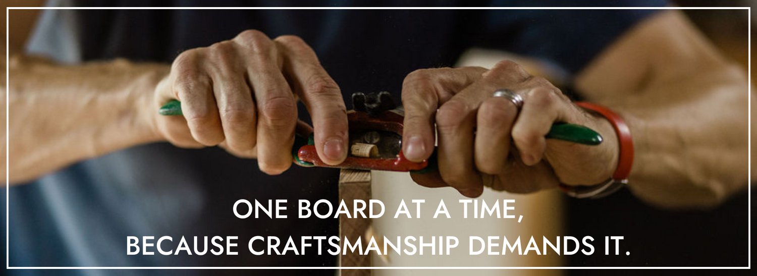 A Deviate longboard being hand shaped with a spokeshave - wood chips flying in the air.